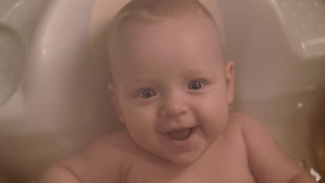 Cute-cheerful-baby-bathing