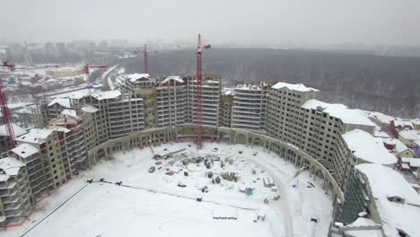 Una-Vista-Aérea-De-Una-Zona-De-Construcción-De-Edificios-Vacíos-En-Un-Paisaje-Invernal