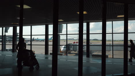 People-walking-in-the-terminal-overlooking-boarding-plane-Moscow-Russia