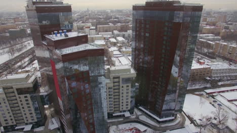 Una-Vista-Aérea-De-Dos-Edificios-Brillantes-En-El-Entorno-Urbano