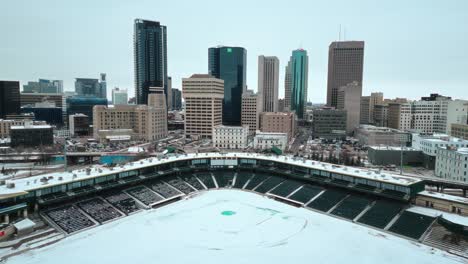 Eine-Statische-4K-Drohnenaufnahme-Von-Wolkenkratzern-In-Der-Innenstadt,-Gebäude,-Arena,-Shaw-Park,-Baseball-Diamant,-Stadtlandschaft,-Winter-In-Der-Hauptstadt-Winnipeg,-Manitoba,-Kanada