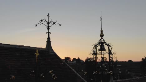 Silhouette-at-sunset-of-Chateau-Angelus-bell-tower-and-decorations-on-roof,-Saint-Emilion-in-France