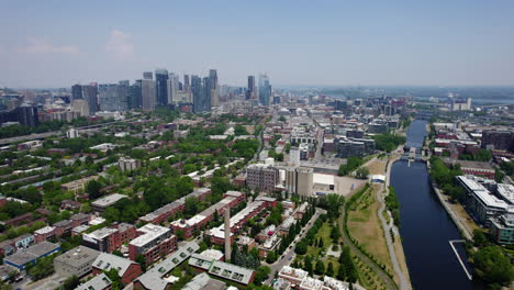 Aerial-view-flying-over-a-neighborhood-with-downtown-Montreal-background