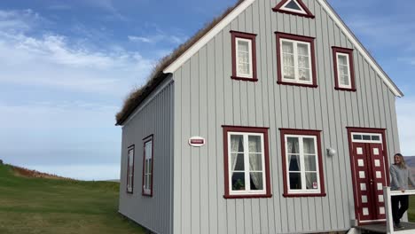 Turista-Posando-En-La-Casa-Tradicional-Islandesa-Con-Techo-De-Césped-En-El-Museo-Glaumbaer