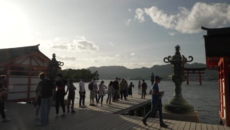 Tourists-Queuing-Up-To-Take-Photo-Of-Itsukushima-Jinja-Otorii-Floating-In-Water-During-Golden-Hour