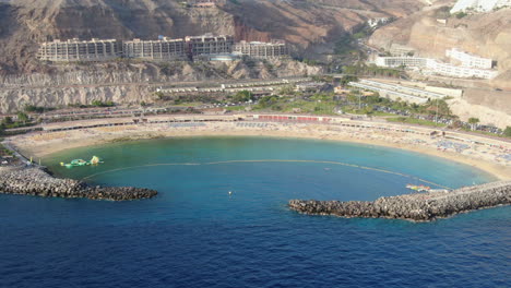Amadores-Beach,-Mogan,-Gran-Canaria:-Meeresbrise,-Flugreise-–-Filmische-Luftaufnahme