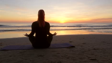 Frau-Meditiert,-Während-Sie-Lotusblumen-Aufführt,-Während-Sie-Bei-Sonnenaufgang-Auf-Das-Meer-Blickt