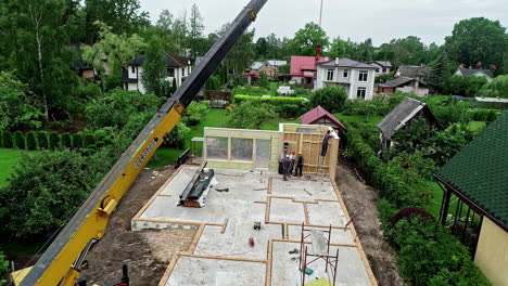 Aerial-view-of-a-crane-at-work-on-the-construction-of-a-prefab-house