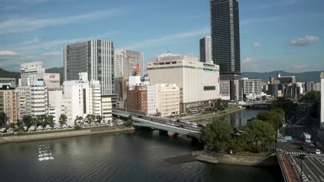 Blick-Auf-Den-Fluss-Kyobashi-Und-Den-Fluss-Enko-Mit-Der-Ihn-überquerenden-Ekinishitakaka-Brücke-Und-Den-Skyline-Gebäuden-Von-Hiroshima-Im-Hintergrund