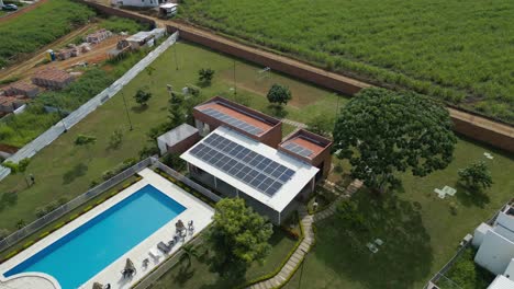 Aerial-view-of-a-private-clubhouse-with-solar-panels-on-the-roof-and-a-swimming-pool