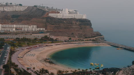 Amadores-Beach,-Mogan,-Gran-Canaria:-Küstenwunder,-Schönheit-Aus-Der-Luft-Mit-Filmischer-Luftaufnahme