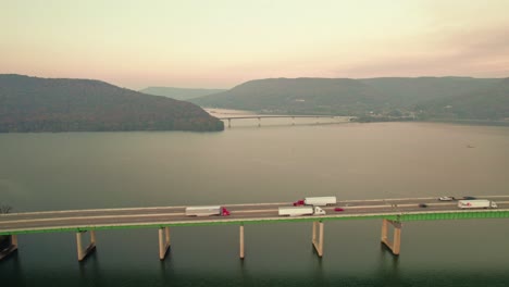 Conductor-De-Camión-Fedex-Entregando-Mercancías,-Antena-Cinematográfica-Del-Puente-Del-Río-Tennessee-Al-Atardecer