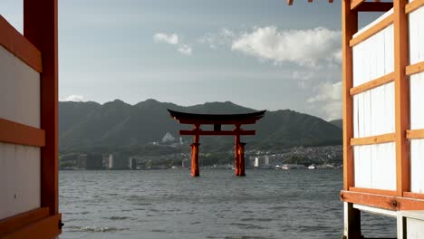 Vista-Cinematográfica-Entre-Dos-Edificios-De-Jinja-Otorii-Flotando-En-El-Agua-En-Itsukushima,-Japón