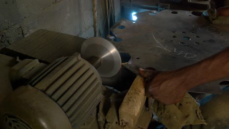 Closeup-Shot-of-Dark-Skinned-Hand-repairing-a-Metallic-Saw-Silversmith-Workspace