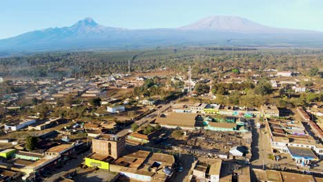 Amanecer:-Paisaje-De-Kenia-Con-Un-Pueblo,-Kilimanjaro-Y-El-Parque-Nacional-De-Amboseli---Seguimiento,-Vista-Aérea-De-Drones