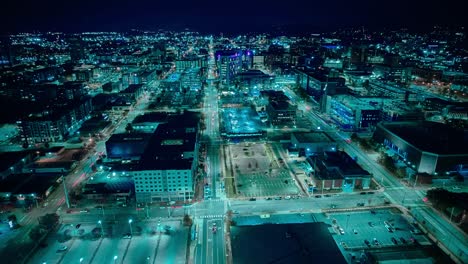 The-vibrant-city-lights-of-Birmingham,-Alabama,-illuminate-the-skyline-and-streets-in-this-nocturnal-high-tech-aerial-view