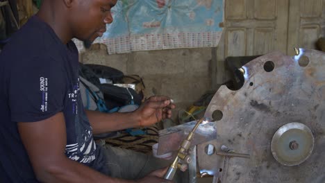 Zeitlupenaufnahme-Eines-Afrikanischen-Silberschmieds,-Der-In-Seinem-Atelier-In-Ghana,-Afrika,-Arbeitet