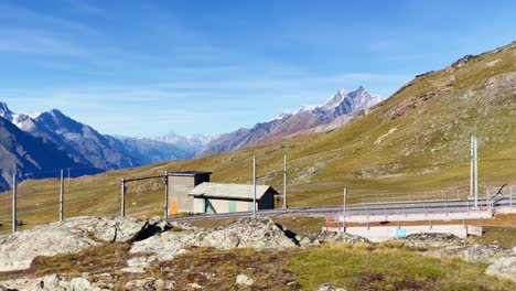 Libertad-De-Montaña:-Paisaje-Montañoso-De-Matterhorn-Cerca-De-Rotenboden-Y-Gornergart,-Suiza,-Europa-|-Mirando-Alrededor-De-Un-Acantilado-Panorámico-Con-Vista-A-Una-Remota-Estación-De-Tren-Y-Caminatas