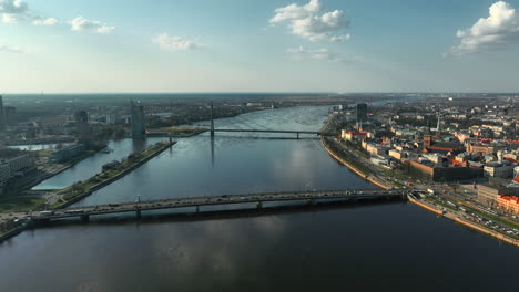 Aerial-panoramic-shot-featuring-Riga's-Vansu-bridge-over-Daugava-river,-near-dome-cathedral,-St