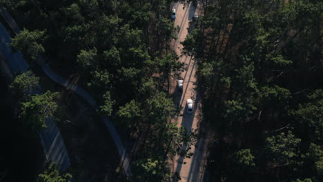 Aerial-top-view-of-cars-on-forest-dirt-road-near-the-beach,-Portugal