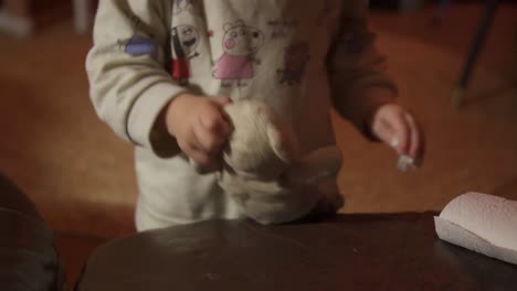 Toddler-playing-with-her-teddy-bear-and-a-tissue,-cleaning-his-face,-taking-care,-static-shot