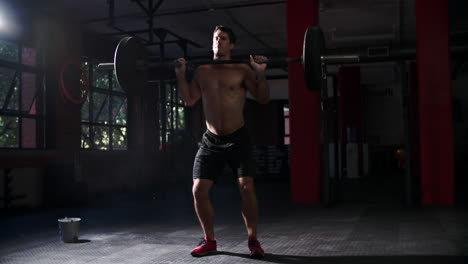 Bare-chested-man-weightlifting-barbells-in-a-gym