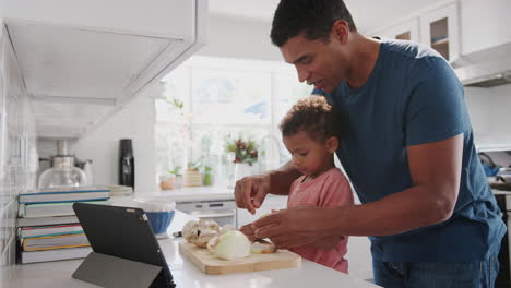 Millennial-African-American-father-and-toddler-son-preparing-food-together-in-the-kitchen,-side-view,-close-up