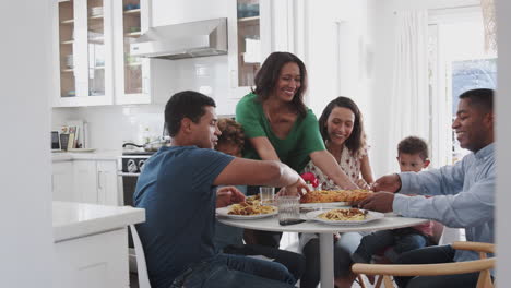 Abuela-De-Mediana-Edad-Sirviendo-A-Una-Familia-Multigeneracional-Afroamericana-Comiendo-Juntos-En-La-Cocina