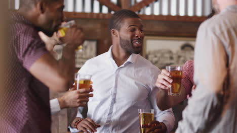 Group-Of-Male-Friends-On-Night-Out-For-Bachelor-Party-In-Bar-Making-Toast-Together
