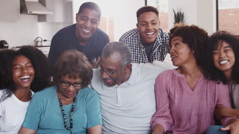 Schwarze-Familien-Aus-Mehreren-Generationen-Sitzen-Entspannt-Zusammen-Zu-Hause-Und-Lächeln-In-Die-Kamera,-Aus-Nächster-Nähe