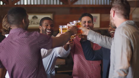Group-Of-Male-Friends-On-Night-Out-For-Bachelor-Party-In-Bar-Making-Toast-Together