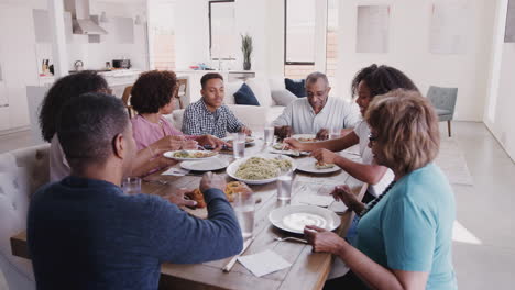 Familia-Negra-De-Tres-Generaciones-Sentados-A-La-Mesa-Sirviendo-Espaguetis,-Vista-Elevada
