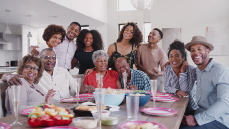 Large-three-generation-black-family-group-portrait-at-dinner-table-during-a-celebration-at-home