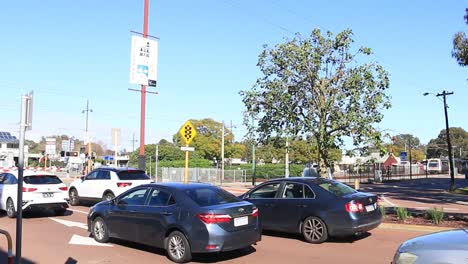 Tracking-shot-of-train-passing-across-vehicle-barrier,-Perth-Australia