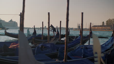 Venice-scene-with-gondolas-mooring-and-sailing-gondolier-Italy