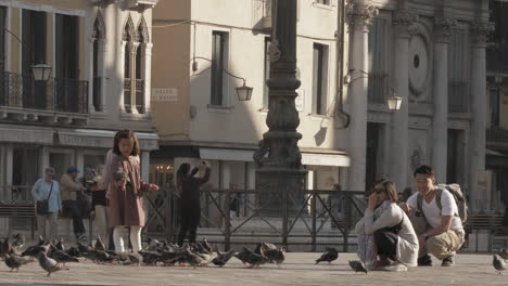 Kleines-Asiatisches-Mädchen-Füttert-Tauben-Mit-Der-Hand-In-Venedig,-Italien
