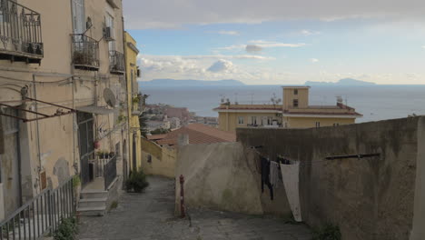 Empty-street-with-old-shabby-houses-and-paved-path-in-Naples-Italy
