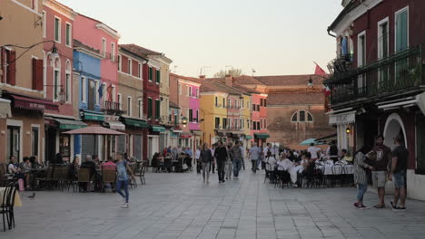 Calle-Animada-En-Burano-Con-Gente-En-Cafés-Al-Aire-Libre-Italia