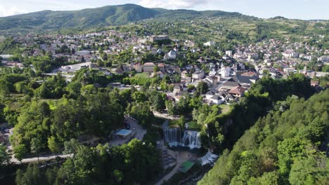 Green-city-Jajce-built-on-a-hill,-ancient-European-village,-aerial-orbit
