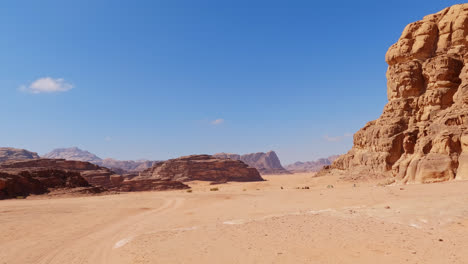 Sweeping-view-of-Wadi-Rum-desert-mountain-valley-region-under-blue-sky