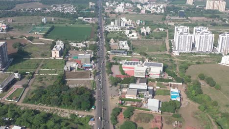Rajkot-city-aerial-view-Camera-moving-forward,-where-box-cricket-is-visible-behind-a-large-field