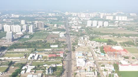 Die-Luftbilddrohne-Der-Stadt-Rajkot-Bewegt-Sich-Vorwärts-Und-Viele-Fahrzeuge-Sind-Auf-Der-Straße-Sichtbar