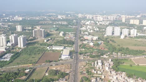 Rajkot-city-aerial-view-Drone-camera-is-moving-forward-and-around-talkies,-showrooms,-houses,-farms-are-visible
