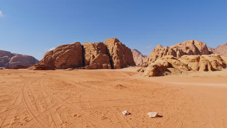 Dolly-push-in-above-tire-tracks-winding-in-sand-of-Wadi-Rum-desert-river-valley