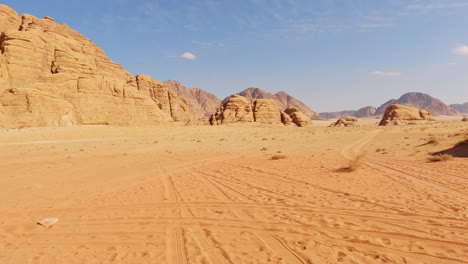Wide-angle-empty-view-of-desert-sand-below-sandstone-cliffs