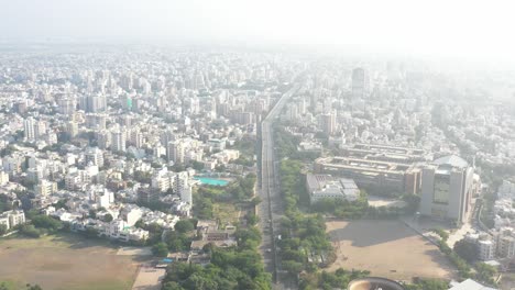 Luftaufnahme-Der-Stadt-Rajkot,-Drohne,-Die-Sich-Aus-Einem-Oberen-Winkel-Bewegt,-Und-Viele-Fahrzeuge,-Die-Sich-Auf-Einer-Großen-Brücke-Bewegen