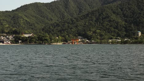 Vista-Del-Santuario-Sintoísta-Itsukushima-Flotante-En-La-Distancia-Visto-Desde-El-Barco-Que-Pasa