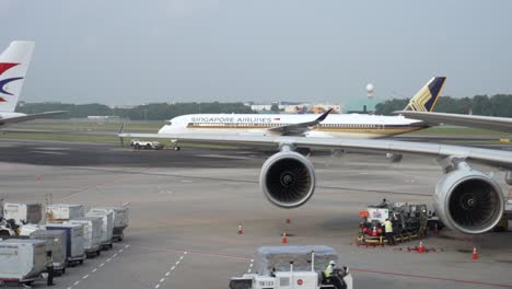 Un-Tractor-De-Remolque-Tira-De-Un-Avión-A350-De-Singapore-Airlines-A-Lo-Largo-De-La-Pista-Del-Aeropuerto-De-Changi