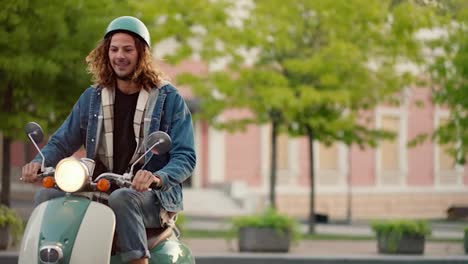 A-guy-with-curly-hair-in-a-denim-jacket-and-a-green-moped-helmet-drives-up-on-his-moped,-meets-his-brunette-girlfriend-in-a-plaid-shirt-and-they-continue-their-journey-together-in-a-summer-city