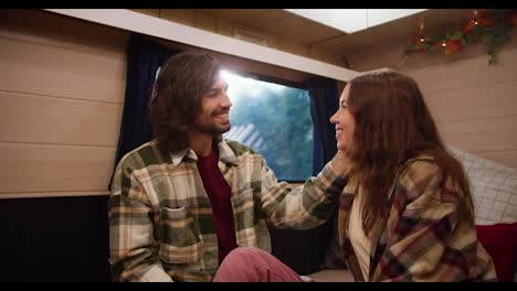 Happy-brunette-guy-in-a-green-checkered-shirt-strokes-his-brunette-girlfriend-in-a-checkered-shirt-during-his-vacation-in-a-trailer-outside-the-city-during-a-picnic-at-a-camp-in-the-summer